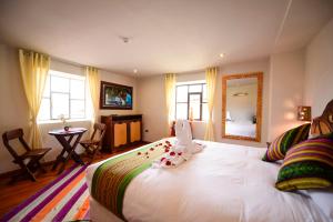 a bedroom with a bed with a mirror and a table at Hotel Boutique Gold Garden in Cusco