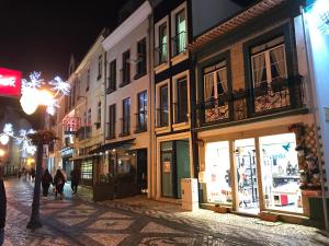 a street at night with people walking down the street at Marquês d'Aveiro Suite in Aveiro