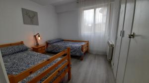 エスカライにあるToki-Goxoのベッド2台と窓が備わる小さな客室です。