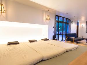 a large white bed in a room with a couch at n-house - Vacation STAY 91411v in Nago