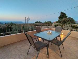une table bleue et des chaises sur un balcon dans l'établissement "Villa Kastania" Melidoni, Crete, à Melidhónion