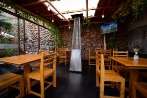a restaurant with wooden tables and chairs and a guitar at Hotel Boutique Gold Garden in Cusco