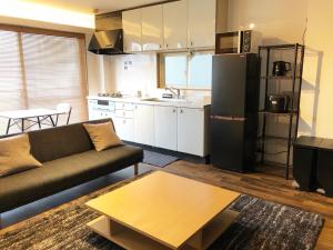 a living room with a couch and a kitchen at Chill Inn Honan - Vacation STAY 94561v in Tokyo