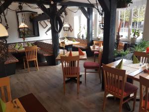 un restaurant avec des tables et des chaises en bois ainsi que des fenêtres dans l'établissement Andi´s Steakhüsli & Hotel, à Schopfheim