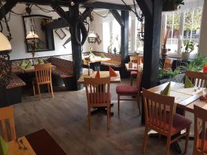 un restaurante con mesas y sillas de madera y ventanas en Andi´s Steakhüsli & Hotel, en Schopfheim