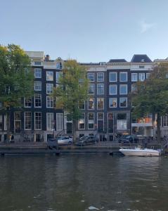 een gebouw naast een rivier met een boot erin bij KG House in Amsterdam