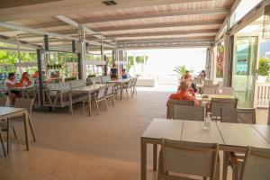 a restaurant with tables and people sitting at tables at Cosmos Hotel in Vasiliki