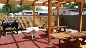 a patio with picnic tables and a grill and a grill at Vagabond Inn Bishop in Bishop