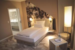 a bedroom with a large white bed and a table at Thöles*** Hotel in Vilsen in Bruchhausen-Vilsen