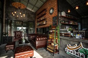 a bar with leather furniture and a brick wall at เรือนร่มไม้รีสอร์ท RuenRomMai Resort in Ban Klang Mun