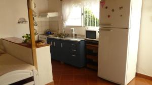 eine Küche mit einem weißen Kühlschrank und einer Mikrowelle in der Unterkunft El Jardin de Nora in Tandil