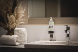 a bathroom sink with a bottle of soap on it at Thöles*** Hotel in Vilsen in Bruchhausen-Vilsen