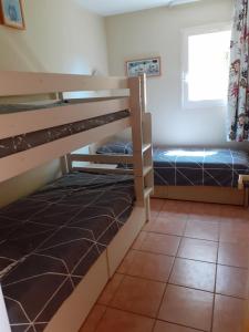 a bedroom with two bunk beds and a window at résidence Bellevue in Roquebrune-sur-Argens