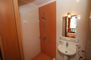 a bathroom with a sink and a shower with a mirror at Tanya Hotel in Sunny Beach