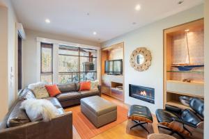 a living room with a couch and a fireplace at Fitzsimmons Walk by Outpost Whistler in Whistler