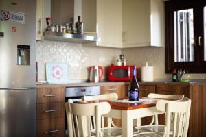 沃洛斯的住宿－Mansion Chalatsopoulos，厨房配有一张桌子,上面放着一瓶葡萄酒