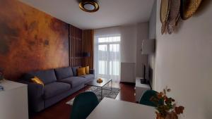 Una sala de estar con un sofá azul y una mesa. en Apartment Moser 1303, en Karlovy Vary