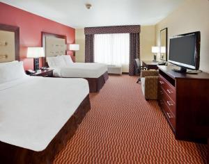 a hotel room with two beds and a flat screen tv at Holiday Inn Express and Suites Great Falls by IHG in Great Falls