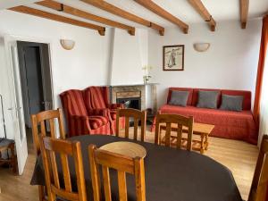 sala de estar con mesa, sillas y sofá en Apartaments Casa Vella Popaire, en Soldeu