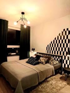 - une chambre avec un grand lit et un mur en damier dans l'établissement Apartament Loft Centrum, à Siedlce