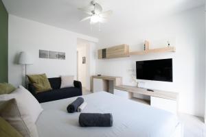 a white living room with a couch and a tv at Homey Apartment in Corralejo Viejo in Corralejo