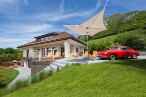 ein rotes Auto, das vor einem Haus parkt in der Unterkunft Villa Bagatelle - Vision Luxe in Veyrier-du-Lac