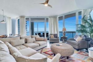 a living room with a couch and chairs and windows at Bel Sole in Gulf Shores