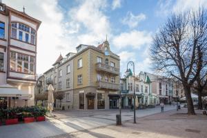 una calle en una ciudad con edificios y gente caminando en Sopot Pier Apartments by OneApartments, en Sopot