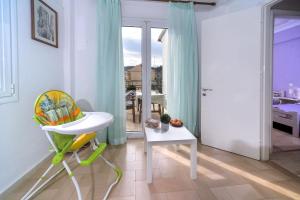 a room with a chair and a table with a window at Penelope - LOGGOS APARTMENTS in Longós