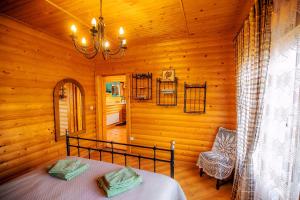 a bedroom with a bed in a wooden room at Country house Domik v derevne in Markovtsy