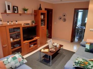 a living room with a couch and a tv at Apartamento Puerto de Foz in Foz