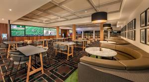 a restaurant with tables and couches and a scoreboard at Blacktown Tavern in Blacktown