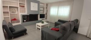 a living room with a couch and chairs and a tv at Apartamento Martin in Tossa de Mar