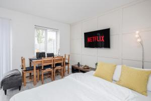 a bedroom with a bed and a table and a desk at Dartford Kent Smart Nest in Dartford