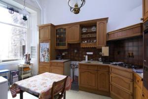 uma cozinha com armários de madeira, uma mesa e uma janela em Quirky, West End, Edinburgh House em Edinburgo