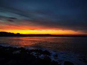 a sunset over a body of water with rocks at The Thoresby - Room Only in Scarborough