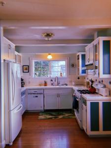 a kitchen with white cabinets and a white refrigerator at Santa Cruz Hostel in Santa Cruz +21 photos