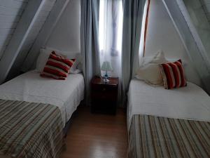 deux lits jumeaux dans une chambre avec fenêtre dans l'établissement Aires del Pipo, à Ushuaia