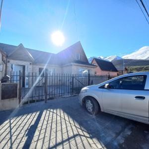 une voiture blanche garée devant une maison dans l'établissement Aires del Pipo, à Ushuaia