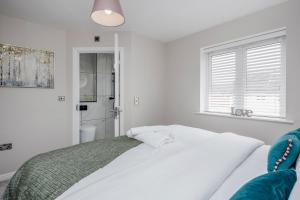 a white bedroom with a bed and a window at Dartford Kent Smart Nest in Dartford
