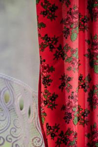 een rood gordijn met een bloemenpatroon erop bij Dom na Wynajem - Bartoszówka in Ochotnica Górna