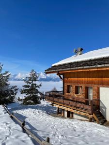 ein Blockhaus im Schnee mit einer schneebedeckten Veranda in der Unterkunft Chalet ALPACA Peisey-Vallandry - Domaine Paradiski in Peisey-Nancroix