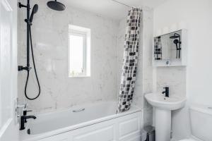 a white bathroom with a tub and a sink at Dartford Kent Smart Nest in Dartford
