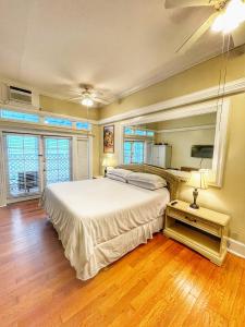 a bedroom with a large white bed and wooden floors at The Casablanca Hotel in Key West