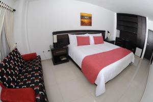 a bedroom with a large bed and a chair at Hotel San José Plaza in Bucaramanga