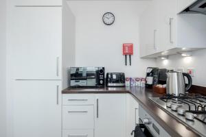 a kitchen with white cabinets and a counter top at Dartford Kent Smart Nest in Dartford