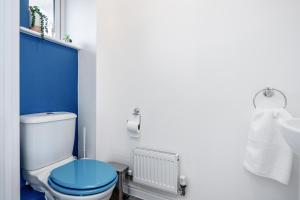 a blue and white bathroom with a toilet and a sink at Dartford Kent Smart Nest in Dartford