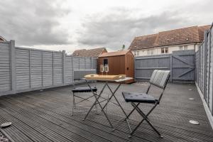 a patio with a table and chairs on a deck at Dartford Kent Smart Nest in Dartford
