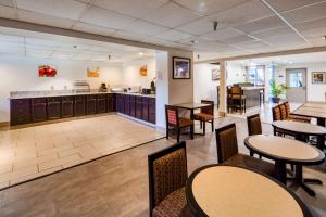 a restaurant with tables and chairs and a kitchen at SureStay Plus Hotel by Best Western Durham Medical Center in Durham