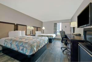 Habitación de hotel con 2 camas y escritorio en Motel 6 McDonough, GA, en McDonough